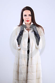 Elegant model in white fur coat of mink