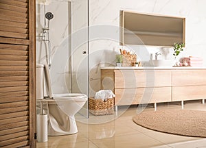 Elegant modern bathroom with cabinet near marble wall