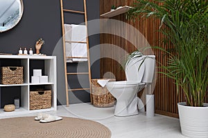 Elegant modern bathroom with toilet bowl near wall