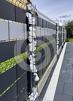 Elegant modern private house fence with ornaments of small white stones