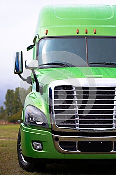 Elegant modern semi truck in green on green parcking lot