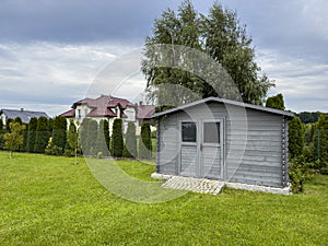 Elegant modern wooden garden shed with lush green lawn