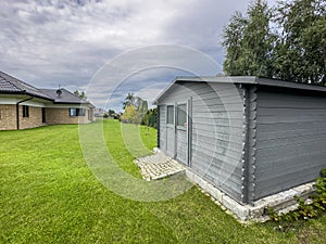 Elegant modern wooden garden shed with lush green lawn