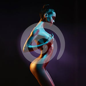 Elegant nude model in the light colored spotlights