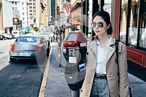 Elegant office lady using parking meter on street