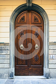 Elegant old double door entrance of brick pink building in Europe. Vintage wooden doorway of ancient stone house. Simple