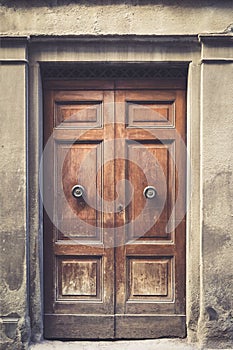 Elegant old double door entrance of building in Europe. Vintage wooden doorway of ancient stone house. Simple brown wood