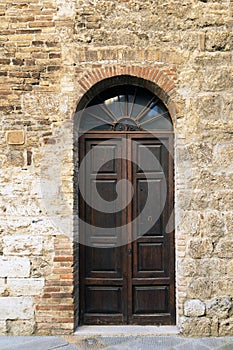 Elegant old double door entrance of building in Europe. Vintage wooden doorway of ancient stone house. Simple brown wood