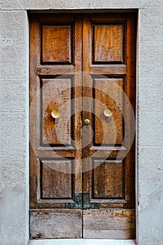 Elegant old double door entrance of building in Europe. Vintage wooden doorway of ancient stone house. Simple brown wood