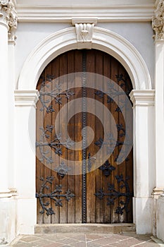 Elegant old double door entrance of building in Europe. Vintage wooden doorway and stucco fretwork wall of ancient stone