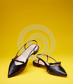 Elegant open-back pointed-toe black women's shoes decorated with bows