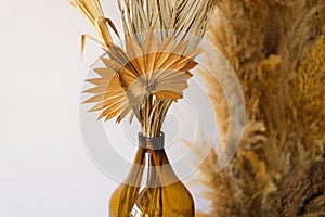 Elegant Pampas Grass Arrangement in an Amber Glass Vase on a Wooden Stand