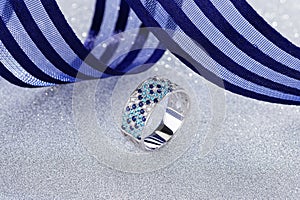 Elegant pave ring with blue and white gemstones on silver background