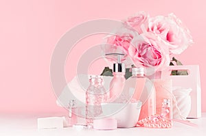 Elegant pink skin and body care products - cream, rose oil, liquid soap, salt, cotton towel and box - cosmetic accessories.