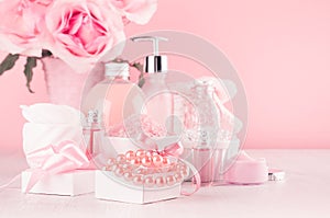 Elegant pink skin and body care products - cream, rose oil, liquid soap, salt, cotton towel - cosmetic accessories, flower.