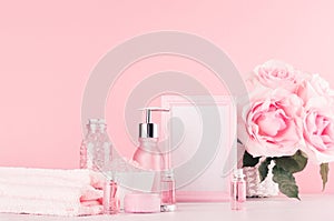 Elegant pink skin, body care products - cream, rose oil, liquid soap, salt, cotton towel - cosmetic accessories, romantic flowers.