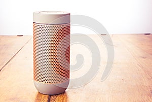 Elegant portable bluetooth speaker isolated on wooden background