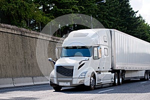 Elegant powerful big rig semi truck transporting dry van semi tr