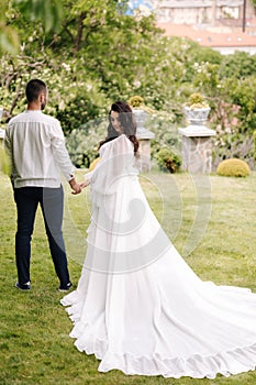 Elegant pregnant woman in luxury white dress walking aroung with her handsome husband