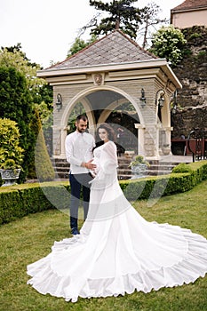 Elegant pregnant woman in luxury white dress walking aroung with her handsome husband