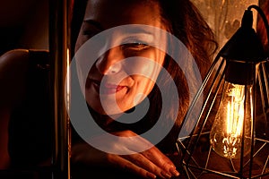 Elegant pretty middle aged woman with nice lamp at the dark room