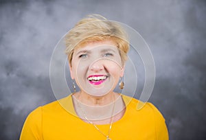 Elegant, pretty middle-aged woman in a yellow dress.