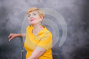 Elegant, pretty middle-aged woman in a yellow dress.