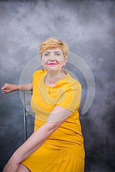 Elegant, pretty middle-aged woman in a yellow dress.