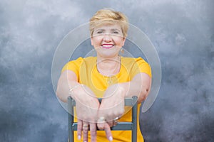 Elegant, pretty middle-aged woman in a yellow dress.