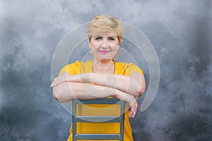 Elegant, pretty middle-aged woman in a yellow dress.