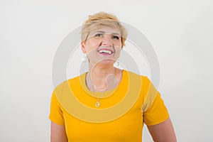 Elegant, pretty middle-aged woman in a yellow dress.