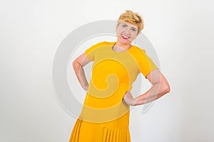 Elegant, pretty middle-aged woman in a yellow dress.