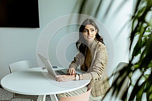 Elegant Professional Woman Working on Her Laptop at a Modern Office Space