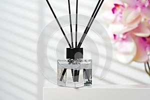 Elegant Reed Diffusers Beside Blooming Orchids in a Bright Interior Setting