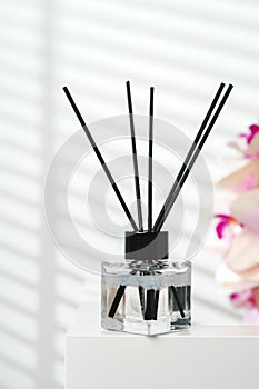 Elegant Reed Diffusers Beside Blooming Orchids in a Bright Interior Setting