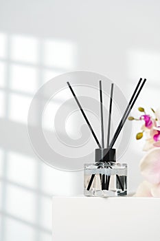 Elegant Reed Diffusers Beside Blooming Orchids in a Bright Interior Setting