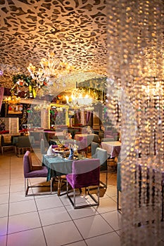 Elegant restaurant interior with purple chairs and green tablecloths