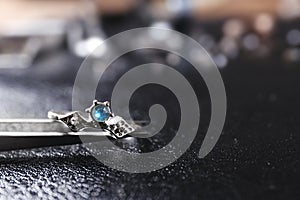 Elegant ring on black  surface, closeup view. Precious jewellery