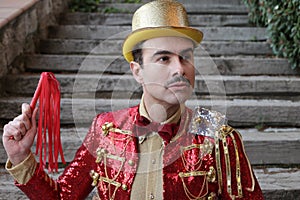 Elegant ringmaster holding red leather whip