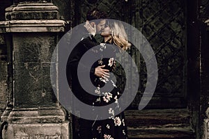 Elegant romantic couple kissing near old metal gate in Paris, be