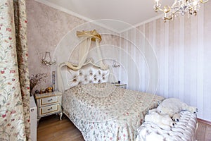 Elegant Royal white bedroom with a large double bed. White Carved back with a small canopy, white bedside tables with curved legs