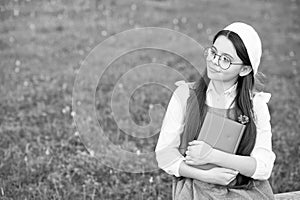 Elegant schoolgirl child girl reading book in park, poetry writer concept