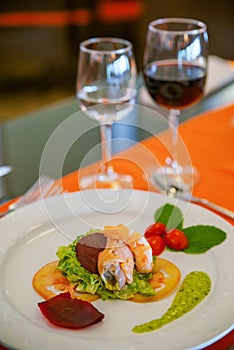 Elegant seafood starter plate with stuffed fish and prongs on a bed of salad dining setup in a restaurant or home