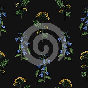 Elegant seamless pattern with embroidered blooming bellflower and tansy flowers on black background. Backdrop with