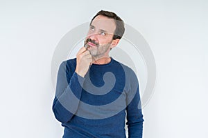 Elegant senior man over isolated background with hand on chin thinking about question, pensive expression