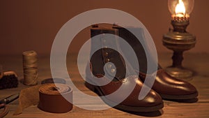 Elegant set: brown wallet, brown men`s shoes, brown leather belt, on the wooden background