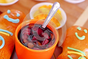 Elegant setup traditional tasty latin american guagua breads, colorful sugar decorations, orange cup with colada morada