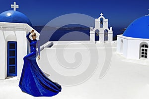 Elegant sexy female model in a blue long evening dress sensually poses against the background of the fabulous landscape of the