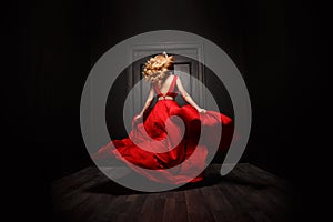 Elegant and woman in the red evening fluttering dress is capture in move, running away from the ceremony photo