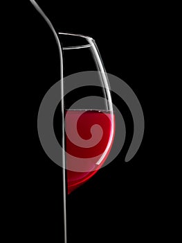 Elegant silhouette bottle of red wine and glass on black background